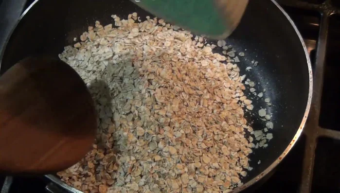 Toast the oats in a pan over medium heat, stirring constantly to prevent burning, until lightly browned.