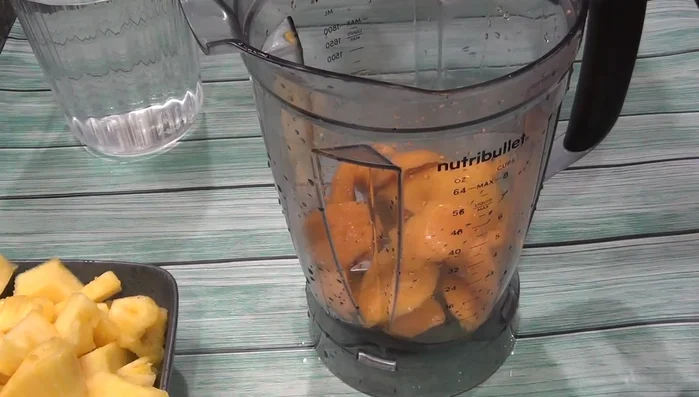 Place the pineapple pulp, mangoes, and a little bit of water into a blender.