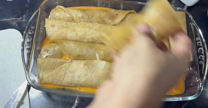 Pour the remaining sauce over the enchiladas, and top with more shredded cheese.